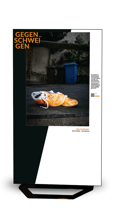 Stele mit einem Paar orangefarbener Loafer auf einer Holztreppe