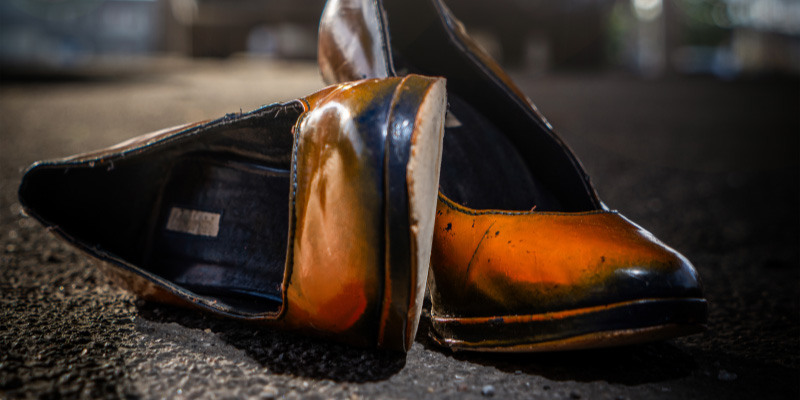 Orange Pumps stehen auf rauem Asphalt